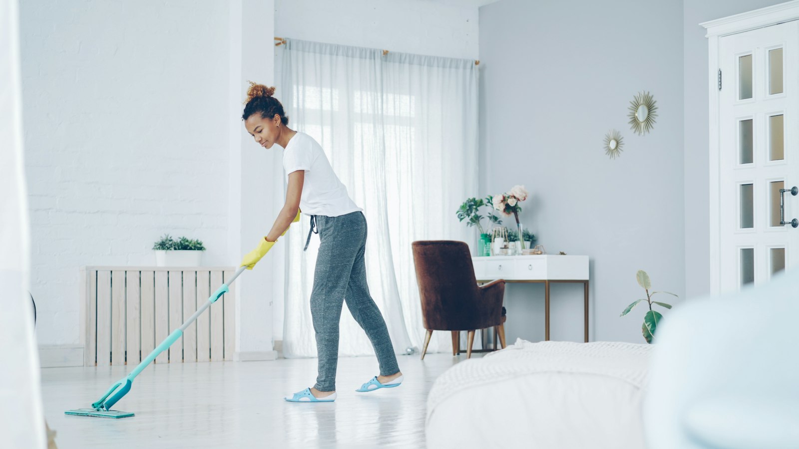 Hourly maid mopping a bright modern living room, comparing maids in Dubai